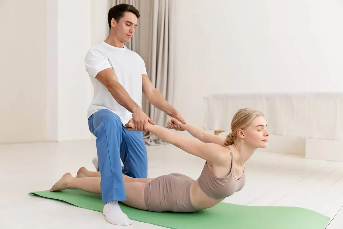 Physical therapist assisting a patient through a targeted back and hip stretch