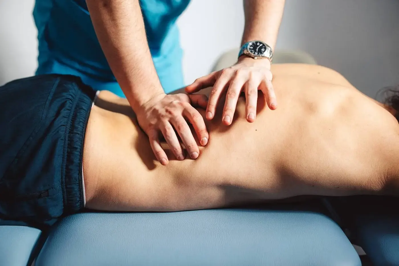 Physical therapist applying manual therapy to a patient's lower back
