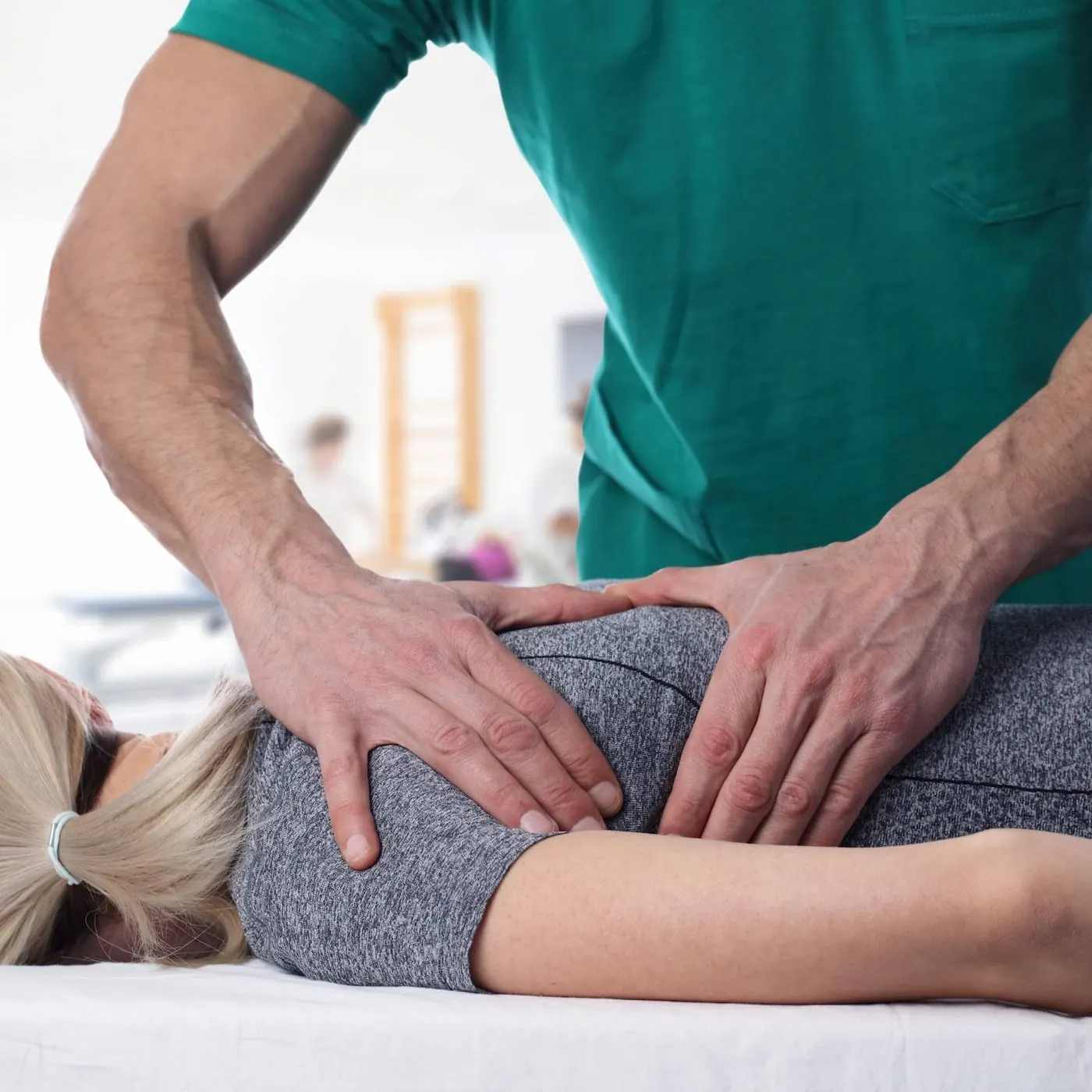 Physical therapist manually adjusting a patient's back