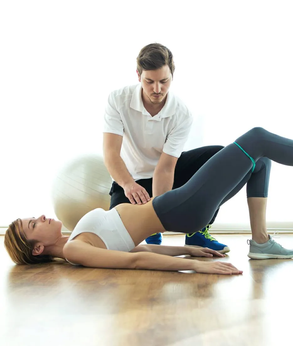 Physical therapist assessing a patient's pelvic and hip alignment during a session