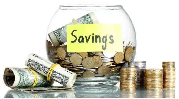 Jar of savings with coins and cash, representing the cost of going to physical therapy first