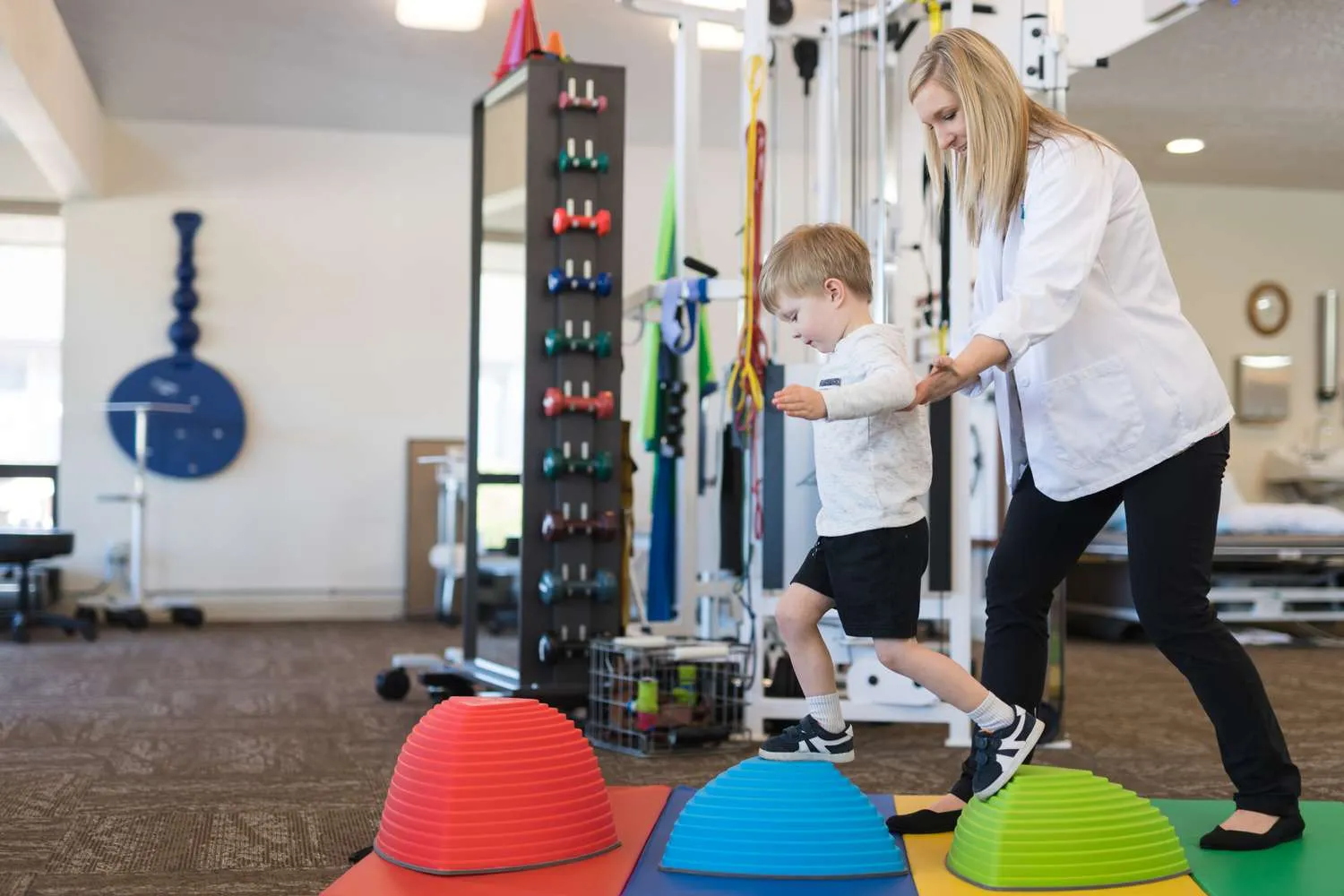 Pediatric physical therapist working with a child during a play-based session